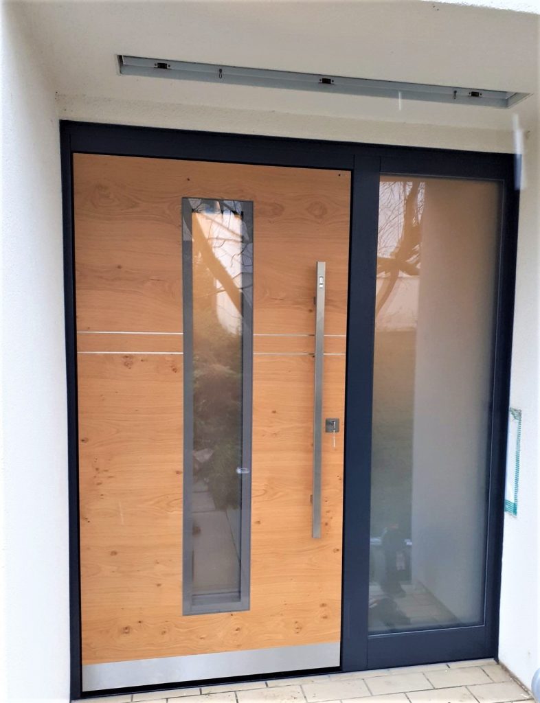 Holztür von Hasler Fenster mit Scheibe in der Mitte, eingebaut als Eingangstür eines Hauses